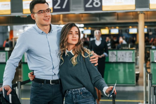 Embracing each other. Young couple is in the airport together.