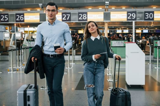 Walking forward. Young couple is in the airport together.