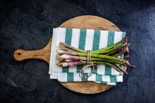 Top view of bunch of fresh asparagus on cutting board