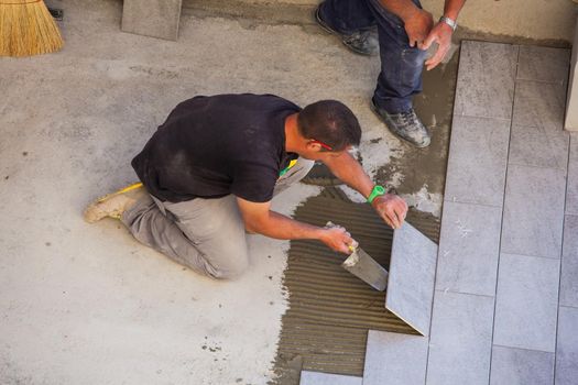 TRIESTE, ITALY - APRIL, 22: Worker Installing ceramic floor tiles on April 22, 2015