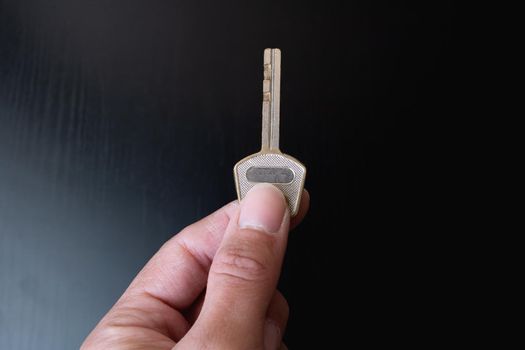 Key in hand on a black background close up