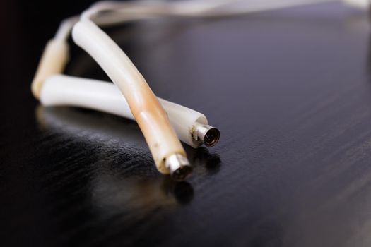 Two white bare wires on wooden background close up