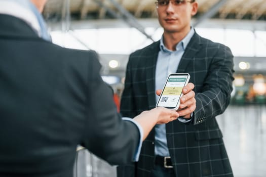 Passing through. Young businessman in formal clothes is in the airport at daytime.