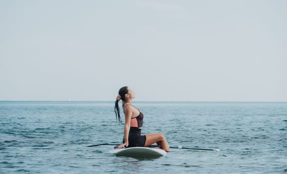 Sea woman sup. Silhouette of happy young woman in pink bikini, surfing on SUP board, confident paddling through water surface. Idyllic sunset. Active lifestyle at sea or river. Slow motion