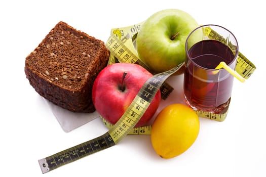 Rye bread with green and red apples and juice in a glass on a white plate with a yellow measuring tape. Diet and healthy food concept