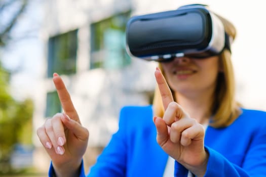 Business woman using VR goggles, moving her head touching the simulation screen in the park.