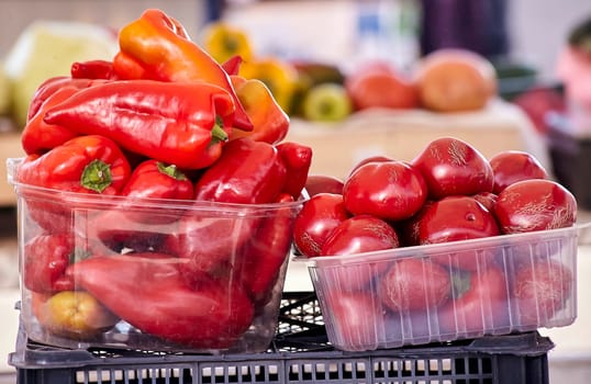 Red chili peppers with vegetables in the market. Tomatoes and peppers are selected by the buyer at the market.