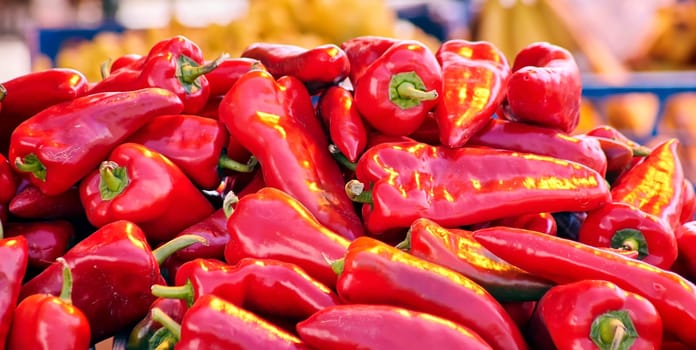 Red chili peppers with vegetables in the market. Tomatoes and peppers are selected by the buyer at the market.