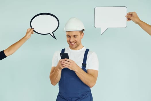 White hard hat and blue uniform. Man standing in the studio with empty signs for the text.