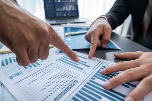 Closeup busy analyst team discussing financial data on digital dashboard, analyzing chart and graph using data science software display on a laptop screen. Business intelligence and Fintech. Fervent