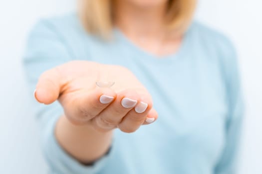 Close up contact eye lens on the tip of the finger.