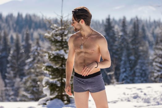 man in shorts and sunglasses on the background of snow-capped mountains