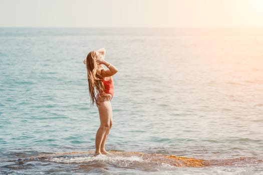 Woman sea yoga. Back view of free calm happy satisfied woman with long hair standing on top rock with yoga position against of sky by the sea. Healthy lifestyle outdoors in nature, fitness concept.