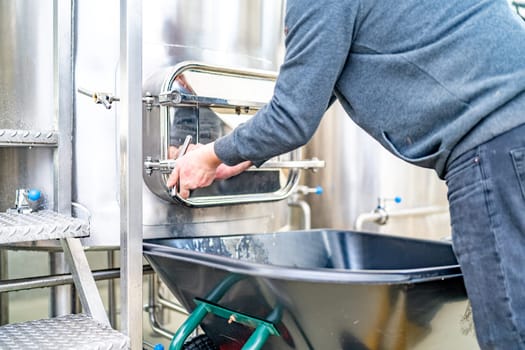 cleaning the boiler from residual malt after brewing beer in the brewery.