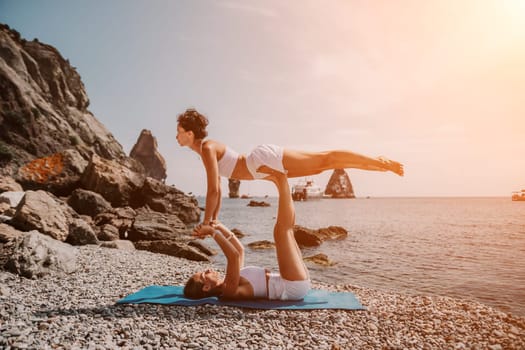 Woman sea yoga. Back view of free calm happy satisfied woman with long hair standing on top rock with yoga position against of sky by the sea. Healthy lifestyle outdoors in nature, fitness concept.