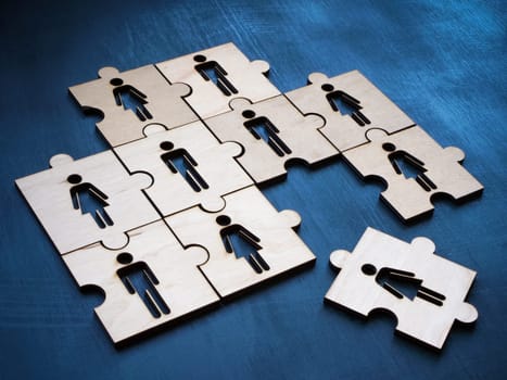Puzzle with figures and one next to each other as a symbol of a new hire in a team.
