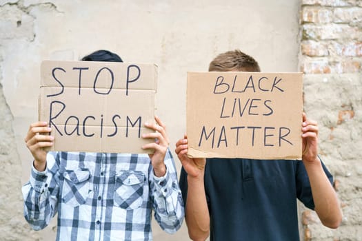 Poster that says black life matters and stop racism in the hands of a young man. Caucasian guy staged a protest demonstration against racism, wrote a slogan on cardboard