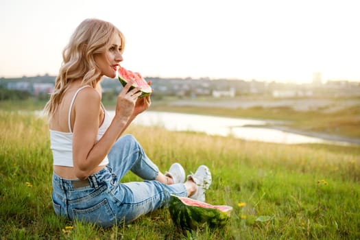 Portrait of a happy young woman enjoying and eating watermelon outdoors, slow life. Summer lifestyle concept. Happiness, joy, holiday independence day.