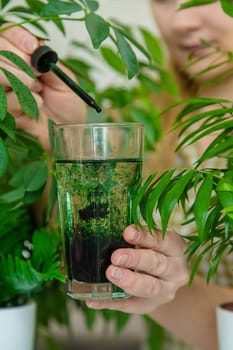 A woman drinks liquid chlorophyll. Selective focus. Nature.