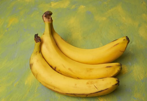 a bunch of three bananas on a yellow-green background