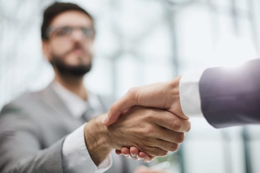 Two diverse professional business men executive leaders shaking hands at office meeting