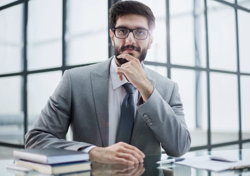 Image of successful businessman rub his beard , having an interesting idea