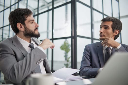 men sitting at a table in a coworking space