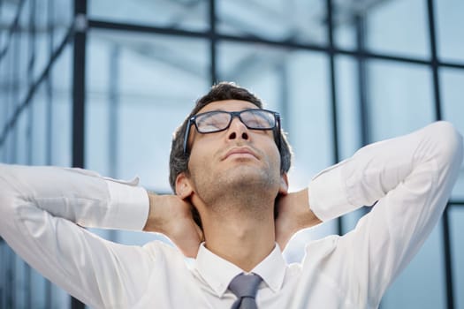 Calm millennial man in glasses sit relax at home office workplace take nap or daydream.