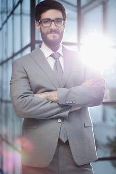 Confident male businessman standing in a modern office.