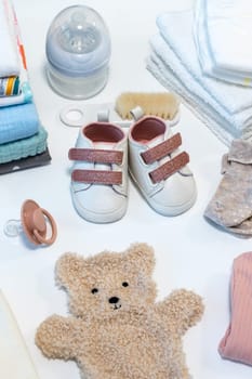 Set of baby shoes, toys and accessories on white background. Newborn stuff. Flat lay