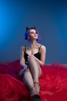 sexy girl posing erotically with a transparent red fabric on a blue background