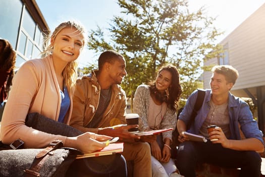 Its important to review your notes everyday. Portrait of a student studying outside on campus with her classmates