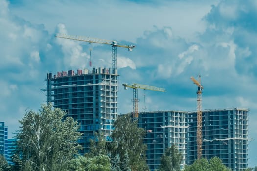 Tower cranes build and development new urban houses architecture industry on blue sky background.