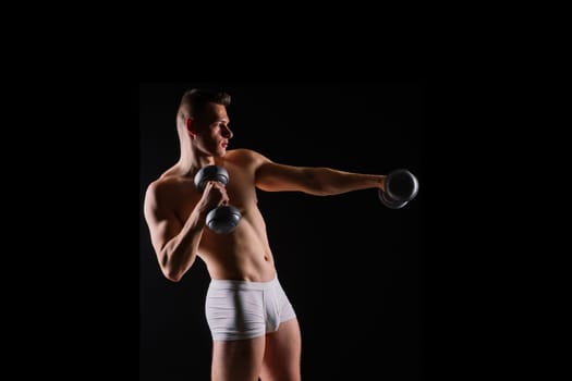 Shirtless bodybuilder holding a dumbell and showing his muscular arms.