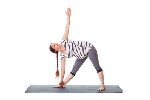 Pregnancy yoga exercise - pregnant woman doing asana Utthita trikonasana - extended triangle pose isolated on white background