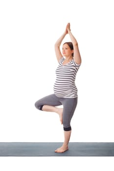 Pregnancy yoga exercise - pregnant woman doing asana Vrikshasana - tree pose isolated on white background