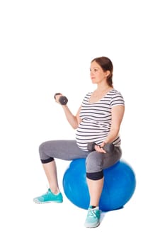 Pregnancy exercise concept - pregnant woman doing exercises with exercise ball and barbells isolated on white background