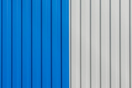 Blue and white vertical lines sheet metal plate corrugated texture steel fence background.