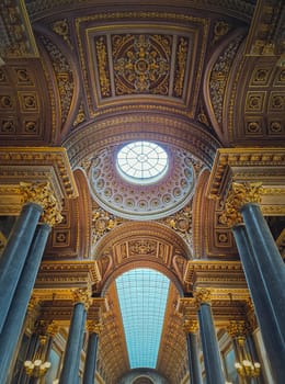 Architectural details with the glass ceiling and golden ornaments inside the Versailles palace hall, Gallery of Great Battles, the largest room in the castle of the sun king Louis XIV