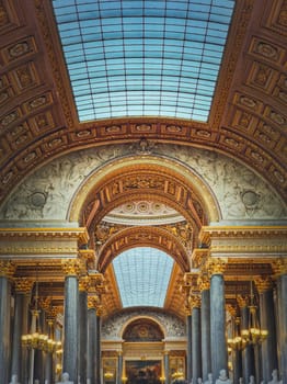 Architectural details of the Gallery of Great Battles hall inside Versailles palace, France. The largest room in the castle, golden ornaments, marble columns and glass ceiling decor