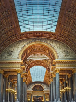 Architectural details of the Gallery of Great Battles hall inside Versailles palace, France. The largest room in the castle, golden ornaments, marble columns and glass ceiling decor