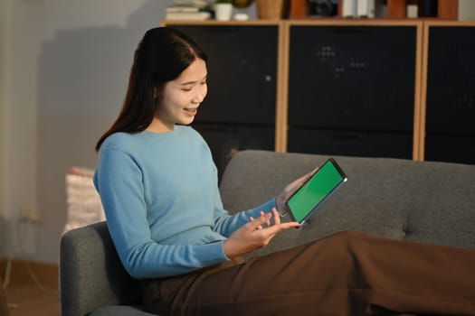 Young woman using tablet on sofa at home. High quality photo