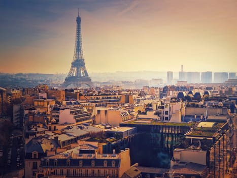 Smog over Paris city, France. Foggy sunset view to the Eiffel Tower due high level of pollution caused by busy urban traffic