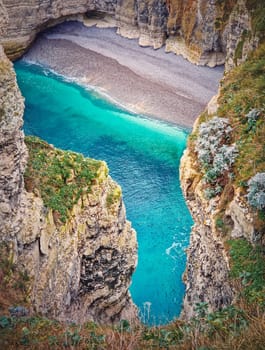 Famous Falaise d'Aval coastline cliffs and a bay with blue ocean water at Etretat, Normandy, France