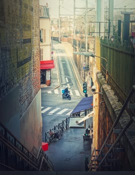 Delivery man or courier driving a motorcycle in the crossroad of city, Asnieres sur Seine, a Paris suburb town, France 