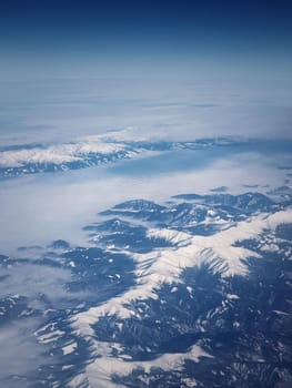 Mountainscape aerial view above the Carpathian mountains snowy peaks, vertical background