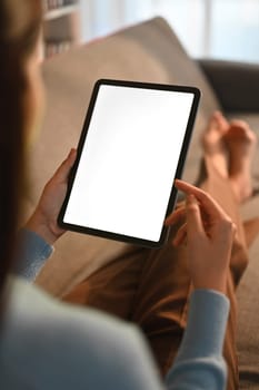 Closeup woman holding empty screen of digital tablet on sofa. High quality photo