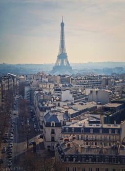 Paris cityscape with view to the Eiffel Tower, France. Beautiful parisian architecture with historic buildings, landmarks and busy city street. Aerial vertical background