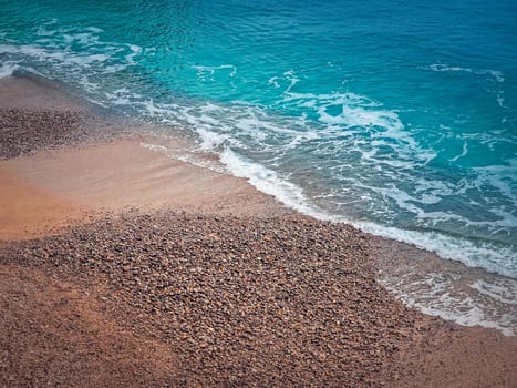 Blue ocean waves hits the shoreline. Beautiful texture of sea water and sandy beach