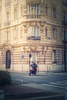 Person driving a motorcycle in the city crossroad, Asnieres sur Seine, a Paris suburb town, France 